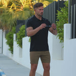 Best black fitted polo shirt with brown fitted chino shorts for muscular build by Kojo Fit