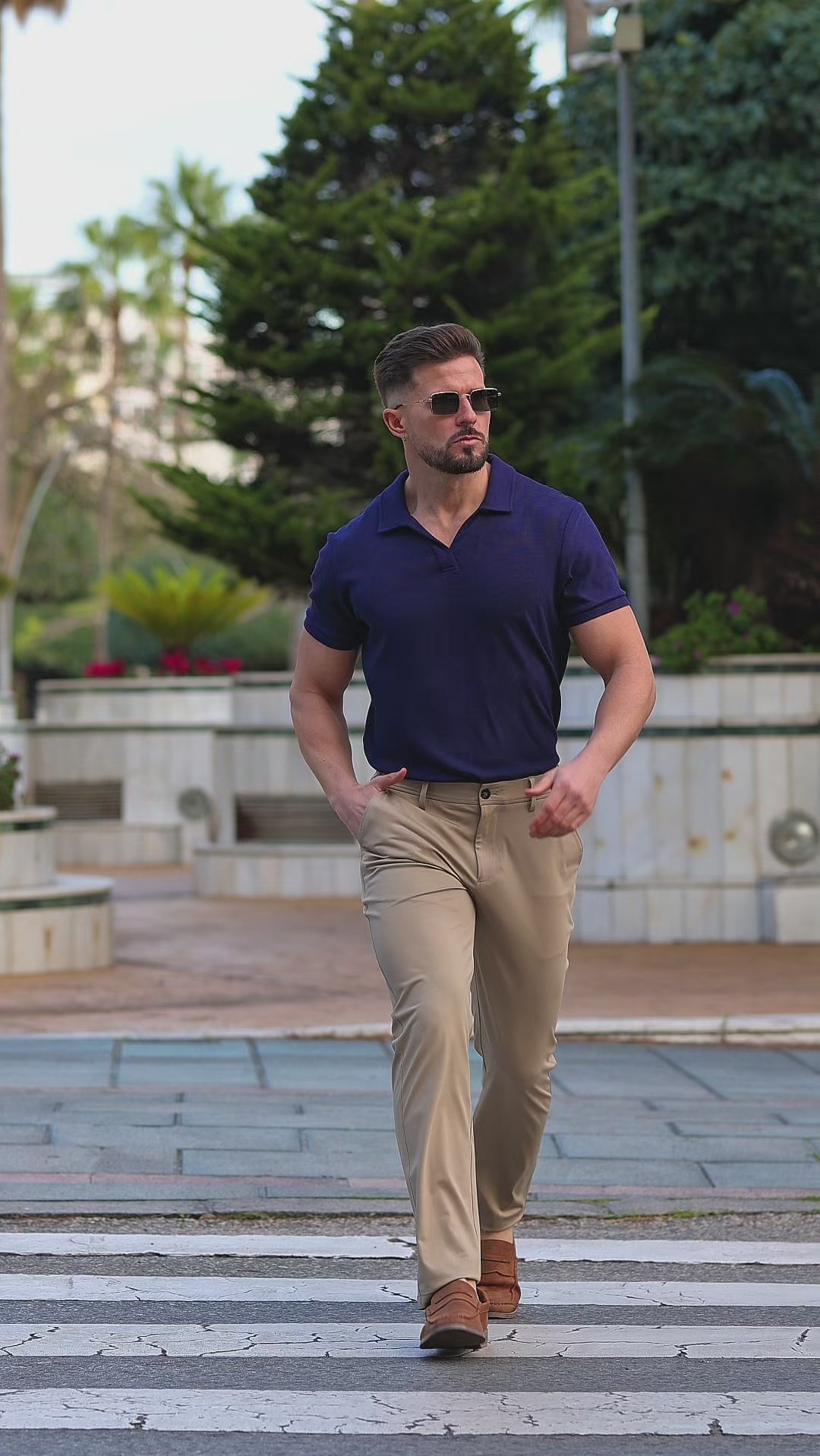 Stylish man wearing avy buttonless polo shirt and brown stretch formal pants outfit