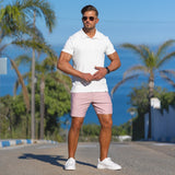 Stylish man wearing white classic knit polo and dusk pink casual slim fit shorts