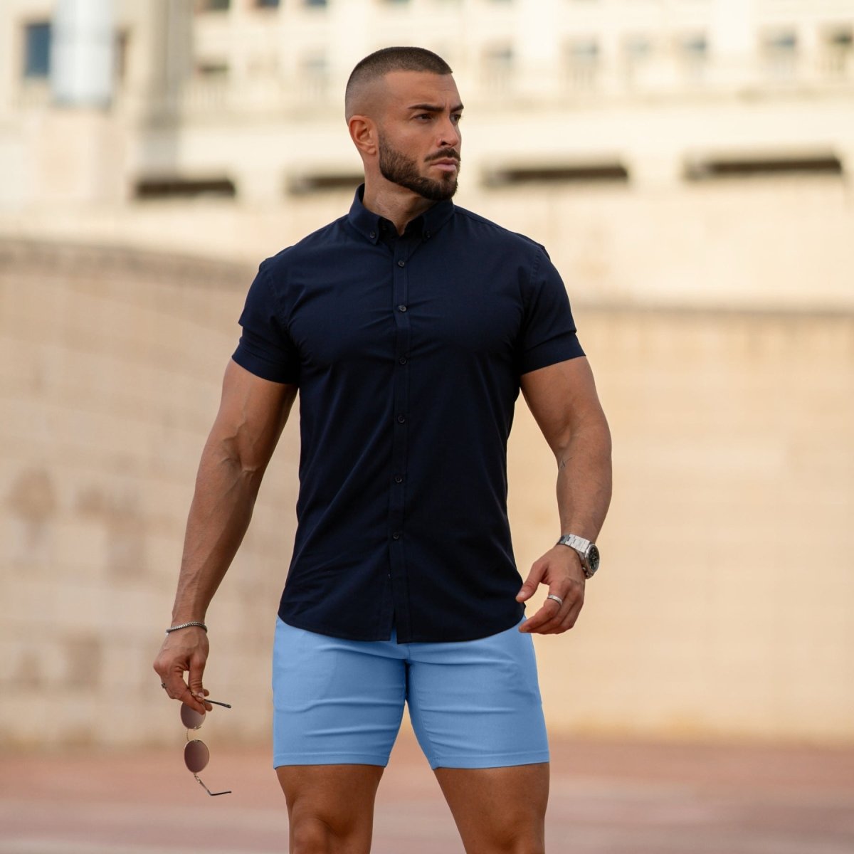Man wearing fitted chino shorts in sky blue with muscle fit shirt outfit